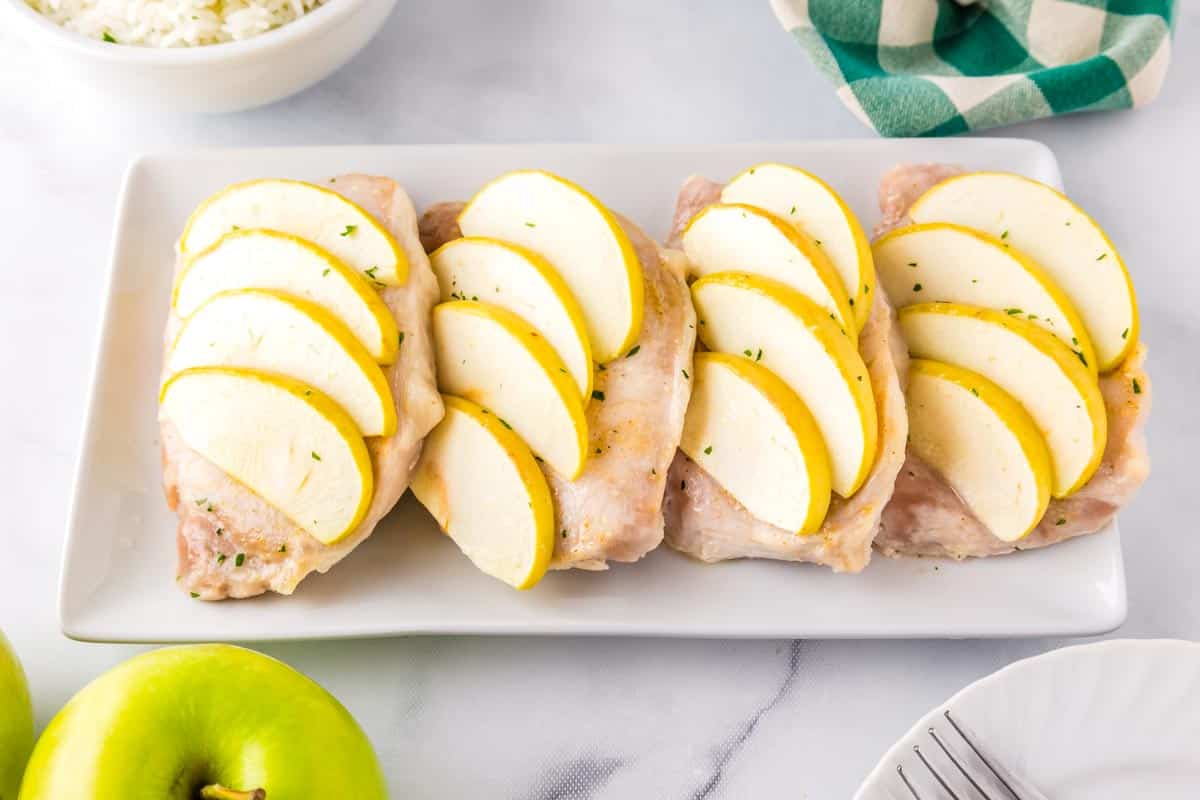 Four pork chops on a white serving platter.