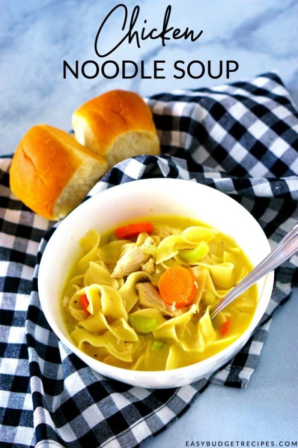 Chicken noodle soup in a white bowl with text overlay for Pinterest.