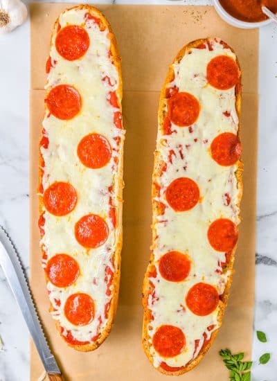An overhead picture of the finished French Bread Pizza on parchment paper before it's cut into slices.