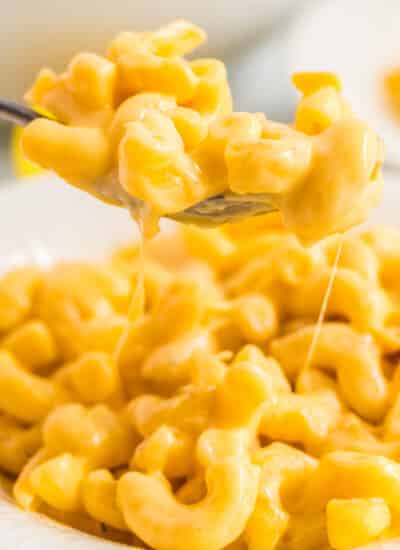A spoon picking up some Mac and cheese.
