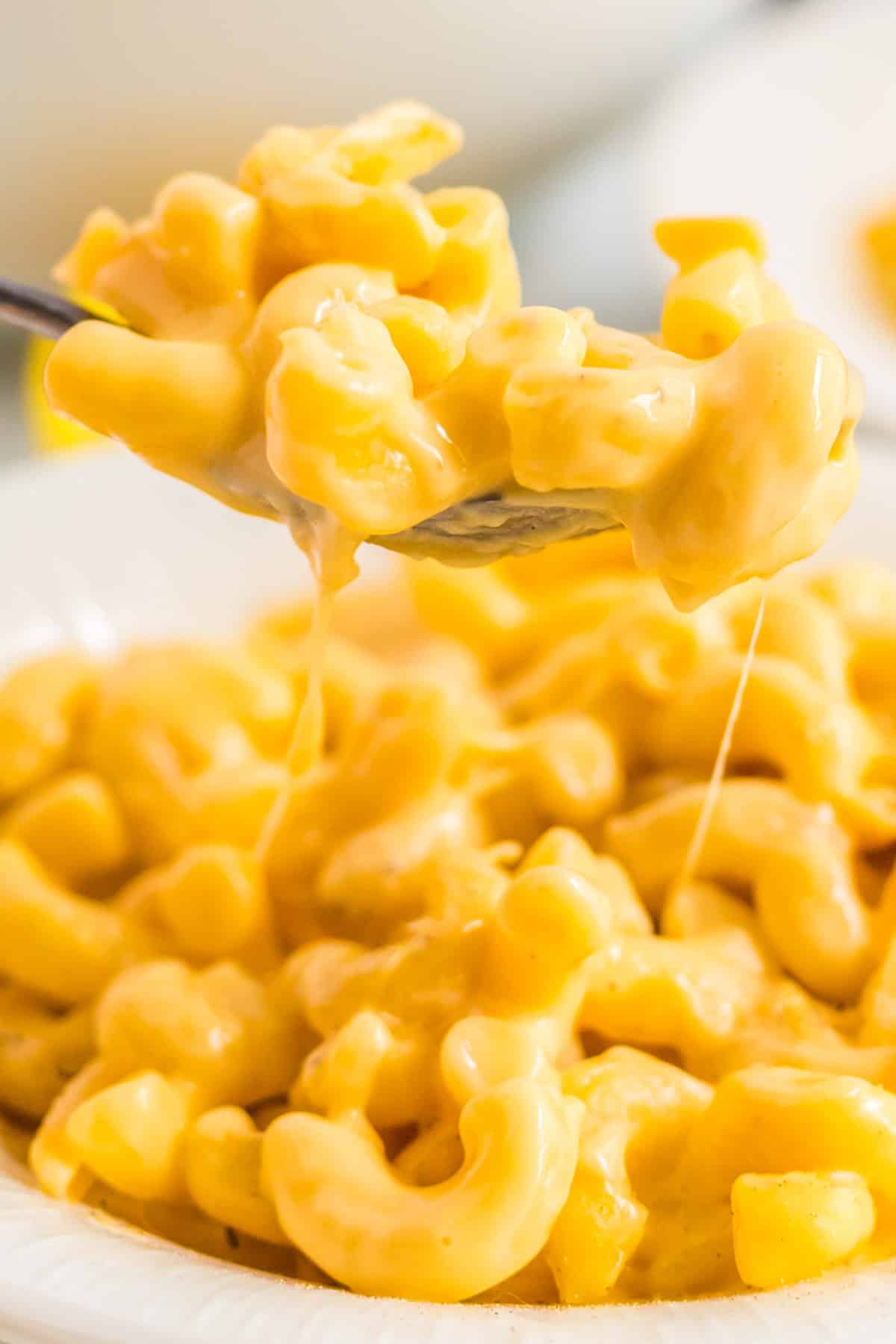 A spoon picking up some Mac and cheese. 