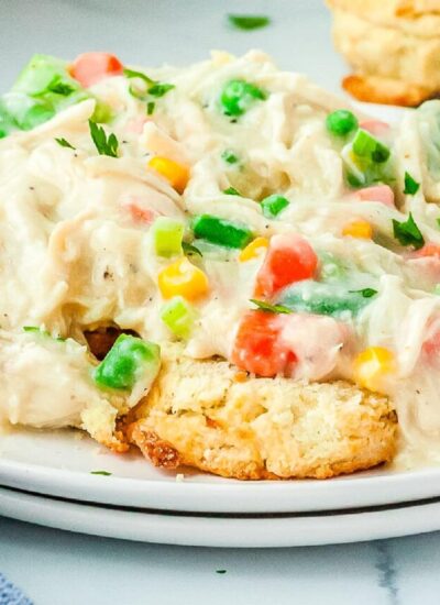 A close up picture of the pot pie mixture served over biscuits.