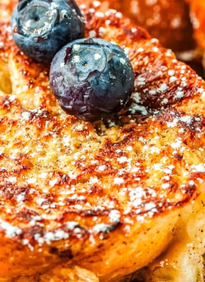 a close up of a slice of french toast with some blueberries on top