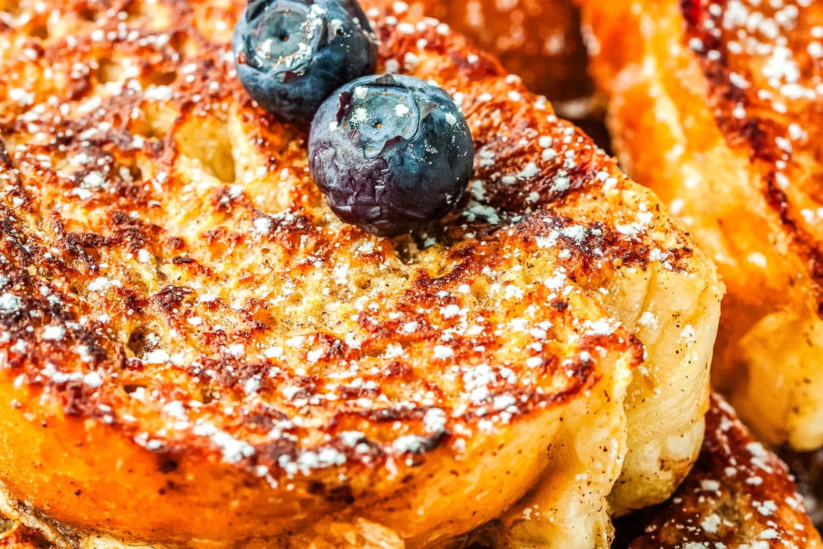 a close up of a slice of french toast with some blueberries on top