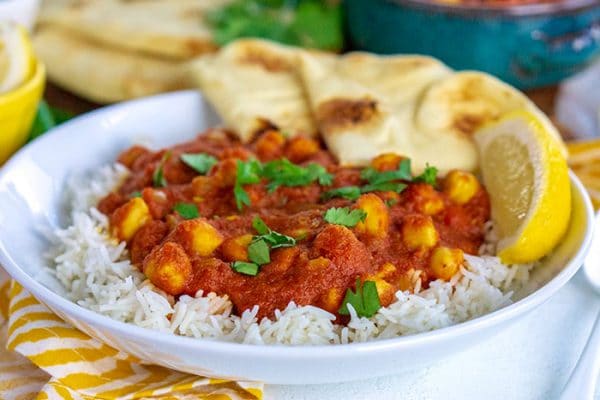 Chana Masala over rice on a white plate.