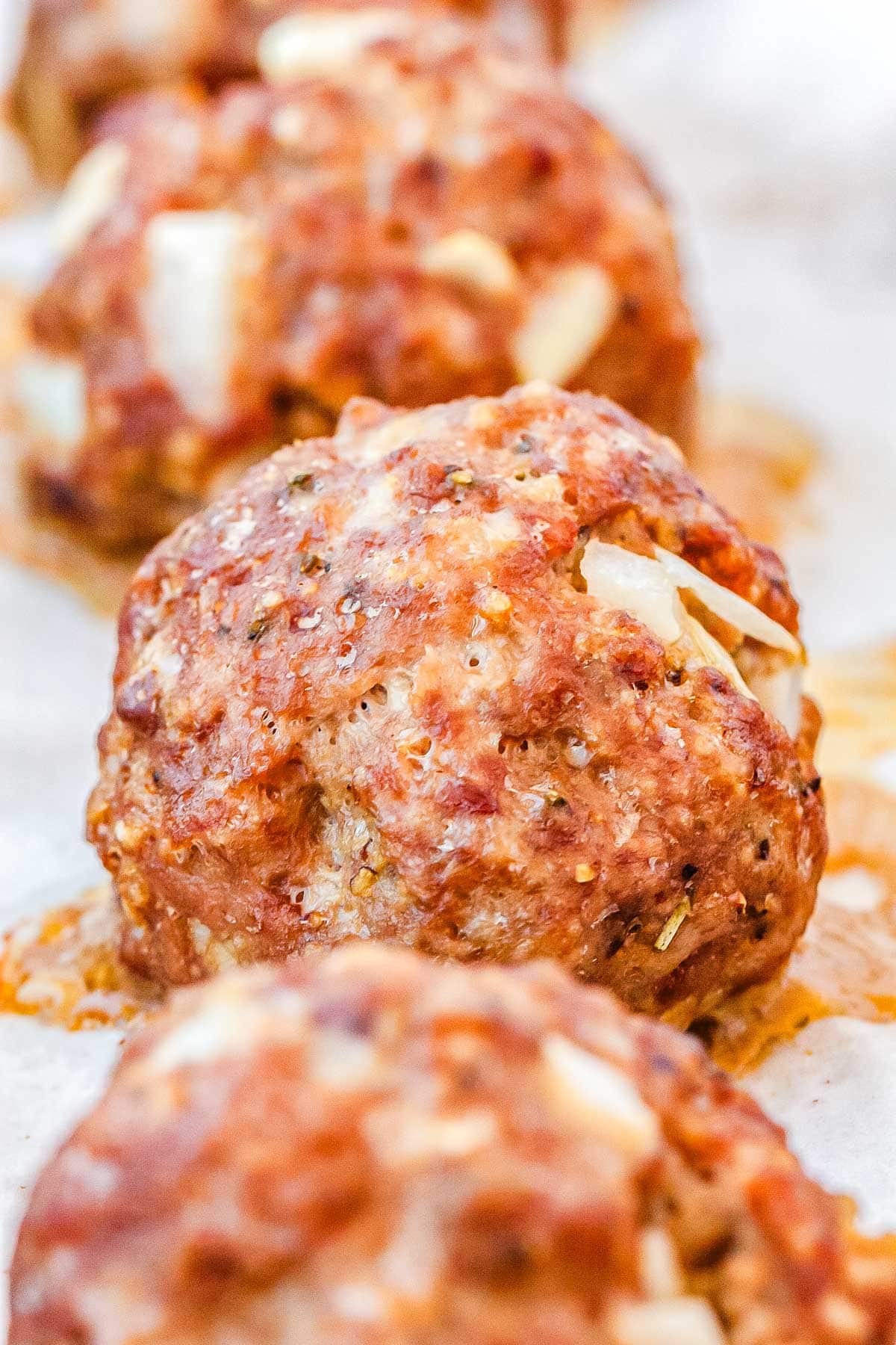 Rows of cooked meatballs on a baking sheet.