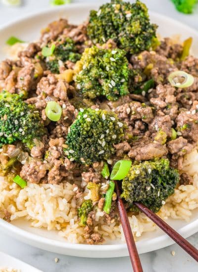 A close up of the finished Ground Beef and Broccoli served over rice in a white bowl.