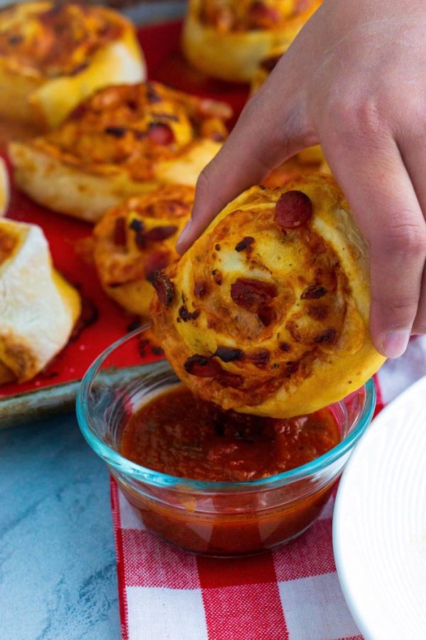 Dipping a pizza roll into pizza sauce. 