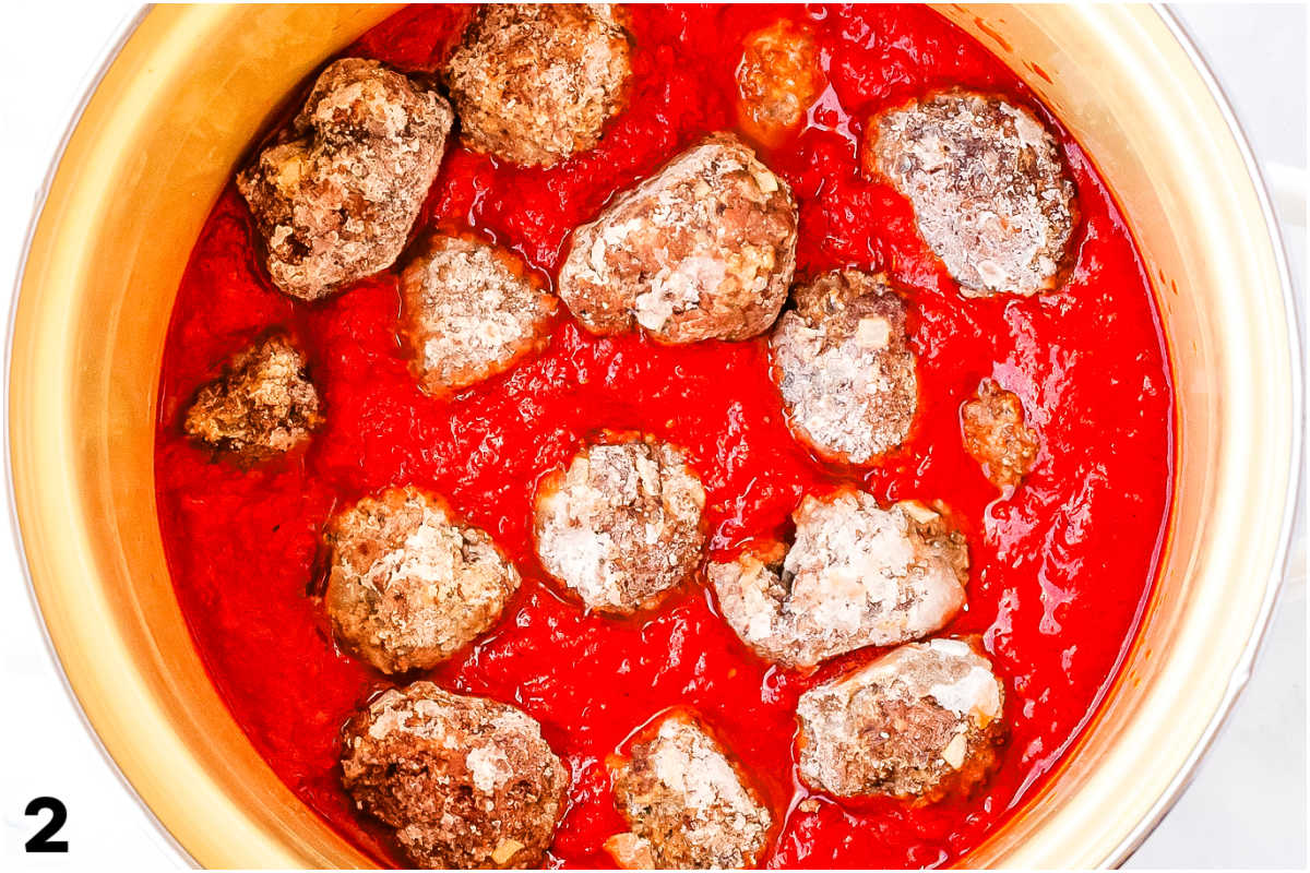 Frozen meatballs in a pot with marinara sauce.