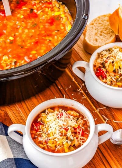 White bowls filled with soup with a crockpot in the background.