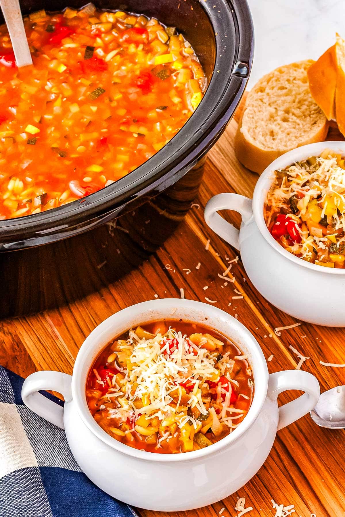 White bowls filled with soup with a crockpot in the background. 