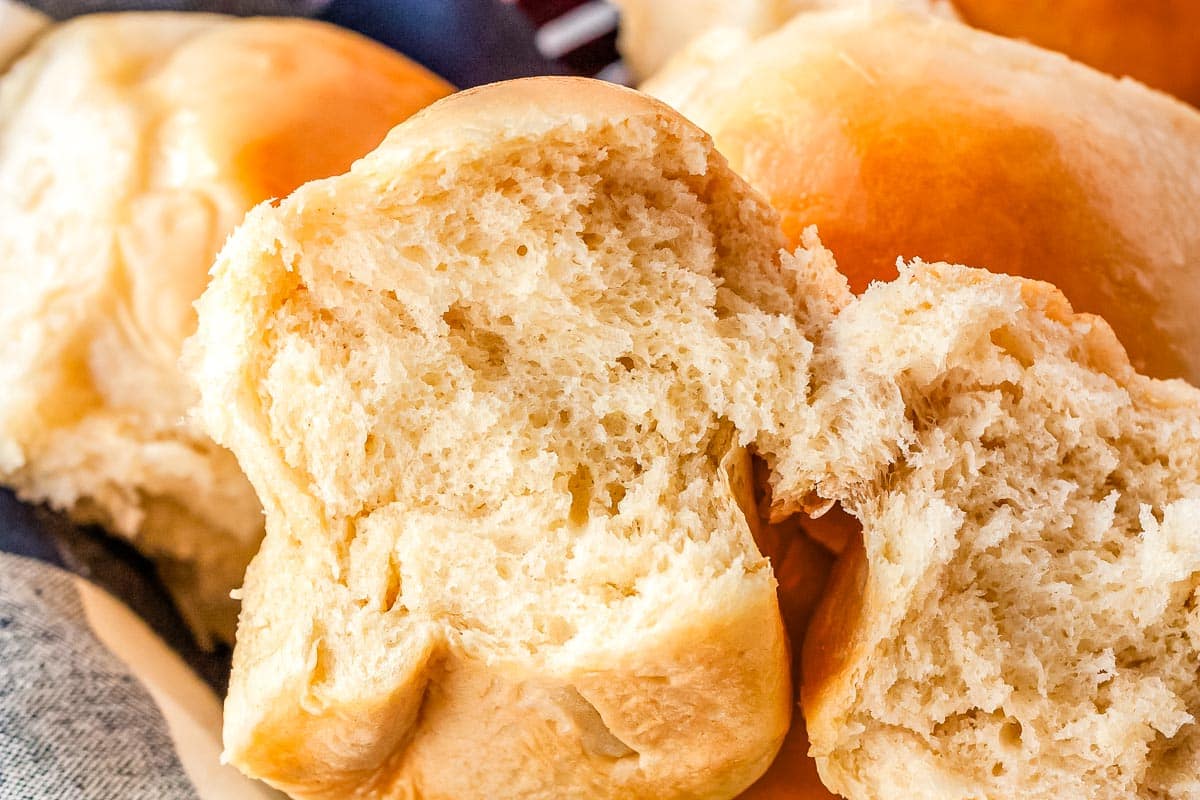 A dinner roll split in half so you can see the soft and fluffy interior.