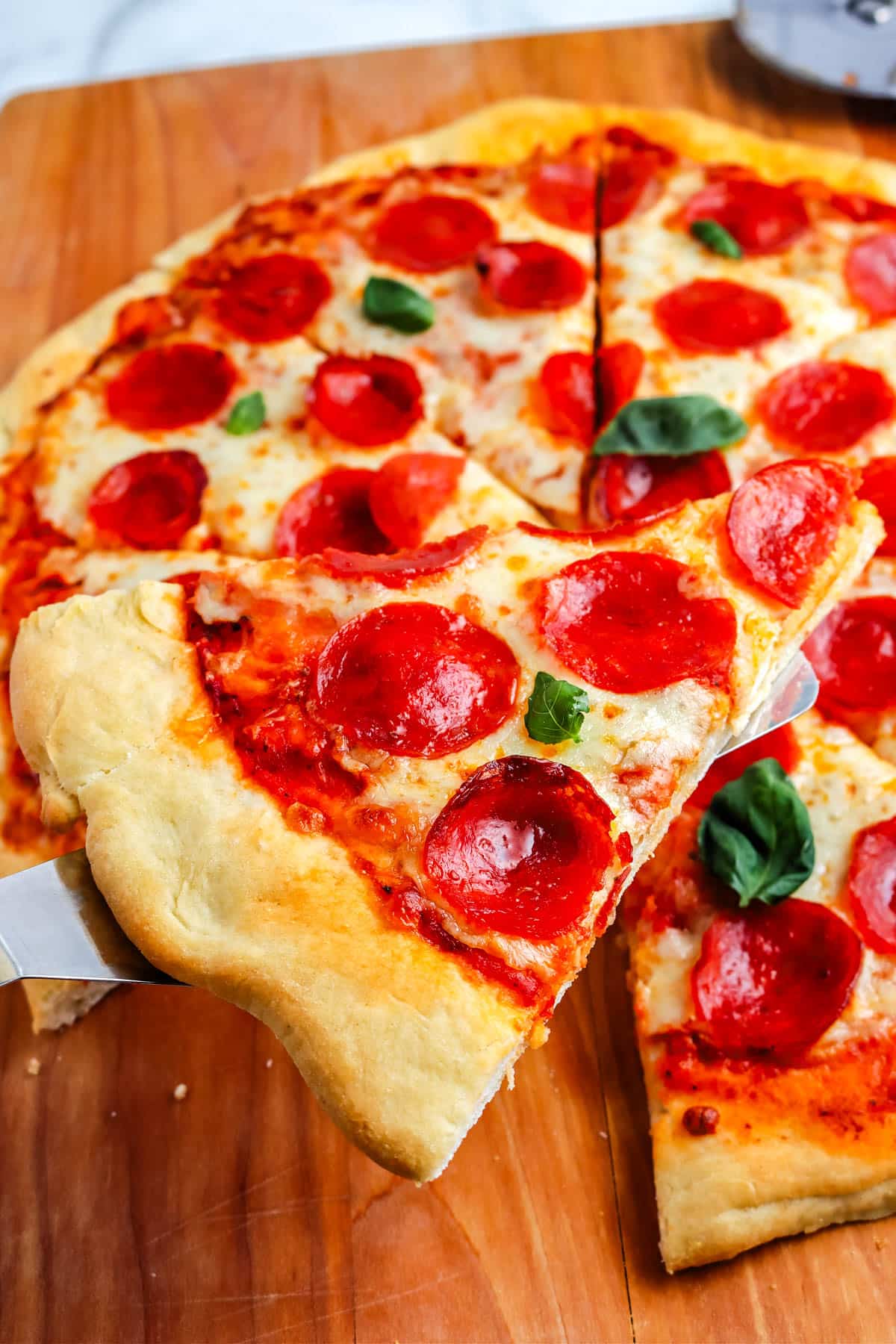 A close up of a slice of pepperoni pizza that's homemade.