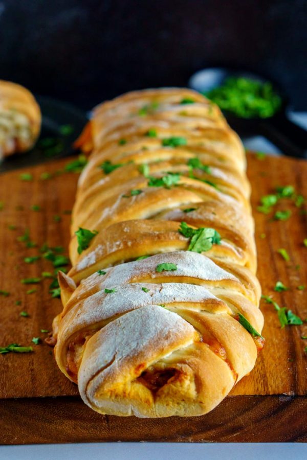 A chicken braid on a wooden cutting board.
