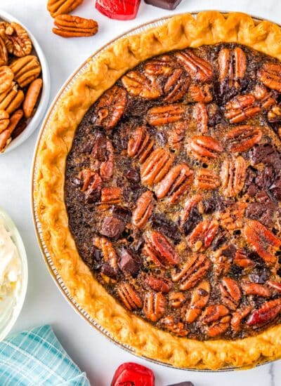 The finished Dark Chocolate Pecan Pie with pecans and dark chocolate surrounding the pie.