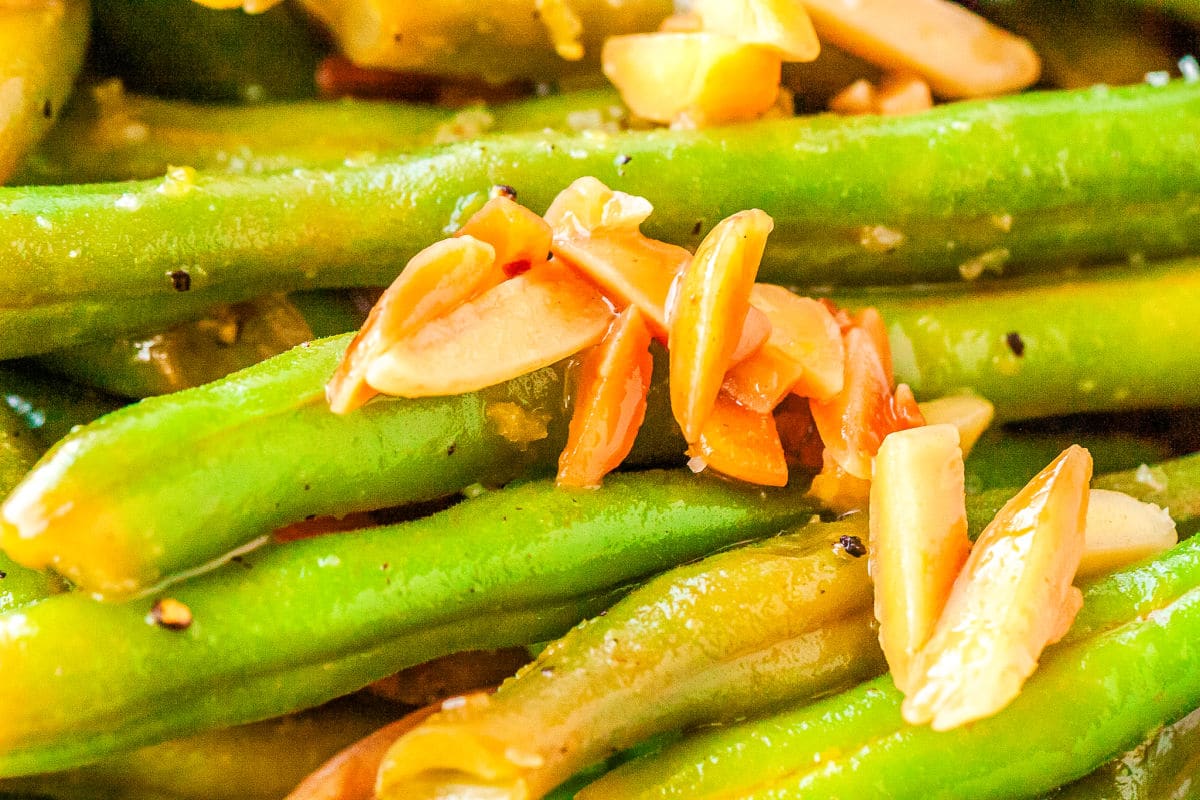 a close up of green beans with toasted almonds