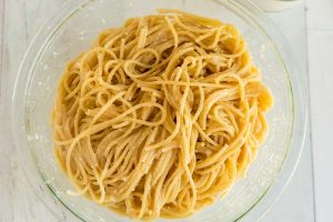 Toss the cooked spaghetti in with egg, butter, and Parmesan cheese.