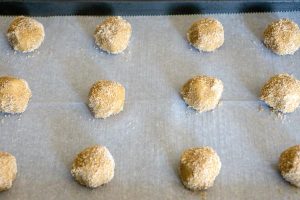 Roll dough balls in brown sugar and place on prepared baking sheet.
