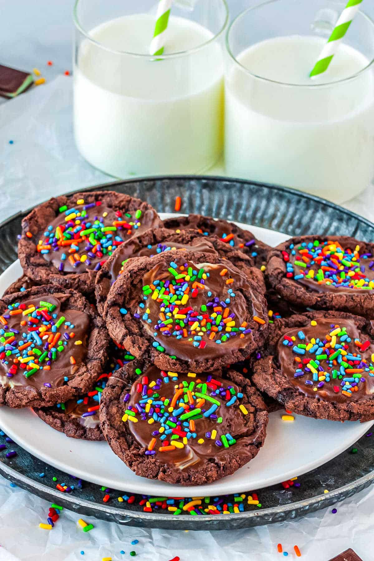 a plate of cookies with glasses of milk