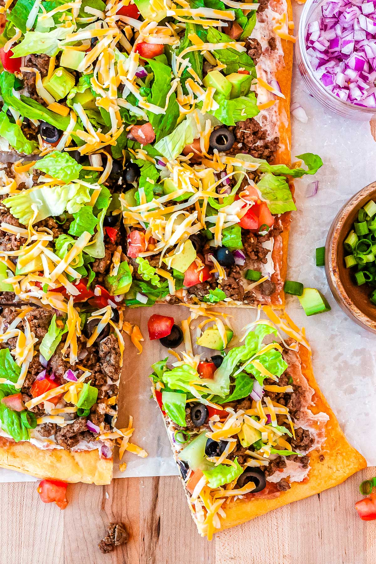 A close up picture of the Crescent Roll Taco Pizza cut into slices. 