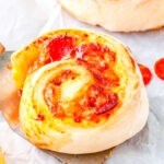 a close up of a pepperoni pizza wheel on a spatula
