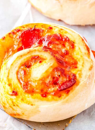 a close up of a pepperoni pizza wheel on a spatula