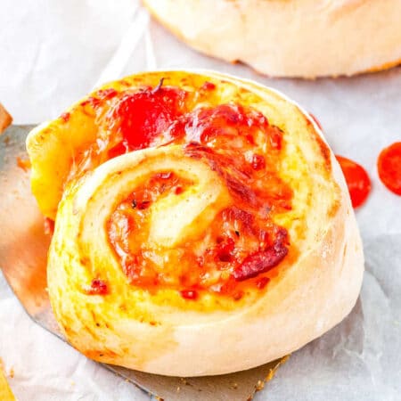 a close up of a pepperoni pizza wheel on a spatula