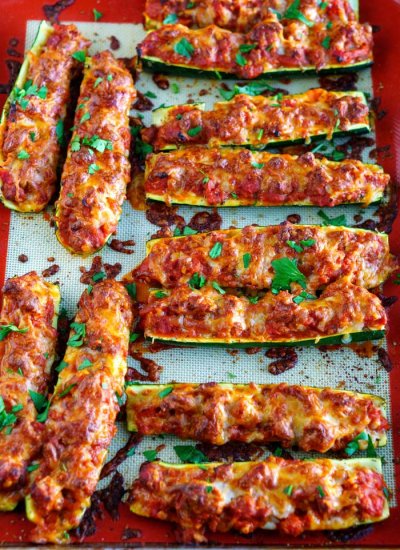 Finished Italian zucchini boats garnished with chopped parsley.