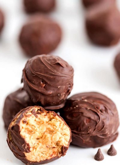 Chocolate Peanut butter bon bons. One ball has a bite revealing the peanut butter and rice Krispy center.