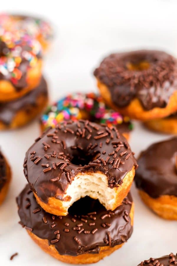 A bite taken out of a chocolate glazed donut.