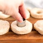 Use a 1 1/2 inch round cookie cutter to cut holes in the middle of the biscuits.