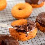 Spread the chocolate glaze over the donuts using a butter knife.