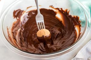 Use a fork to dip the bon bons into the chocolate.