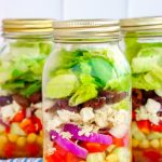 3 Mason jars filled with layers Greek salads.