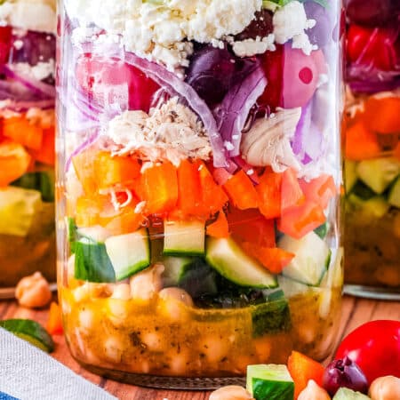 A close-up picture of the layers of the finished Mason jar Greek salad recipe.