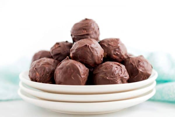A plate of stacked chocolate peanut butter bon bons.