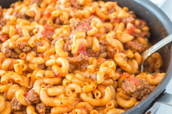 A serving spoon side the finished American Goulash.