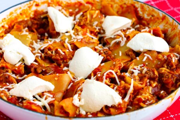 Finished lasagna in a white skillet. 
