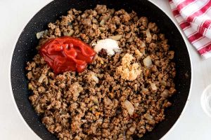 Add the ketchup and other ingredients to the ground beef.