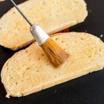 Brush the bread with melted butter.