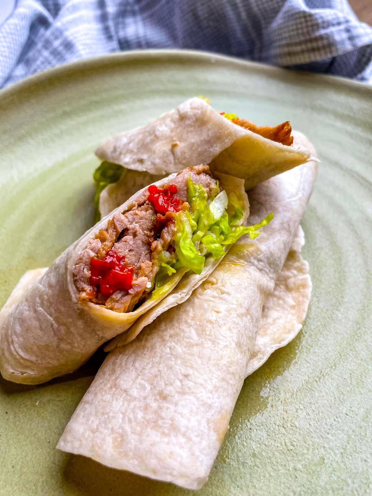 Two burritos on a plate. 