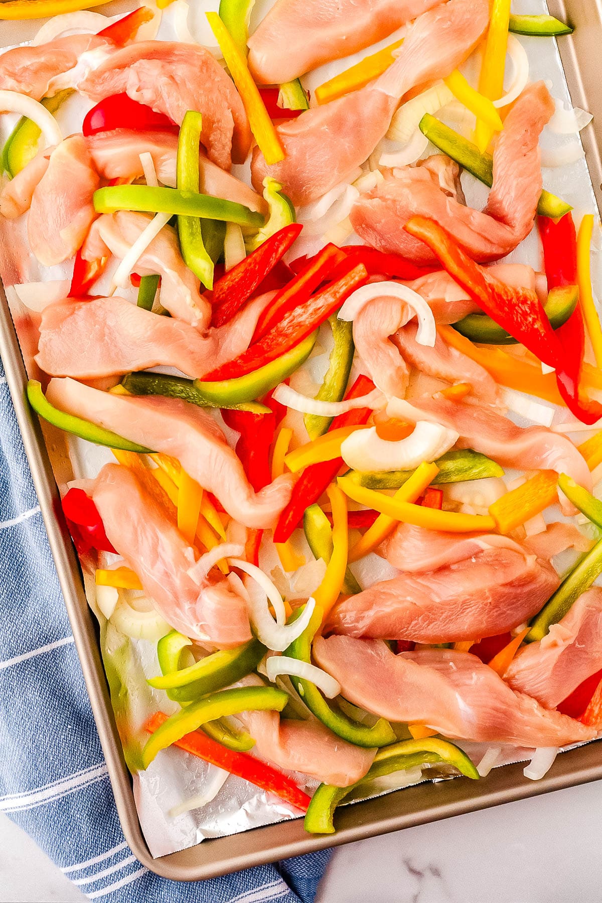 The veggies and chicken on a sheet pan.