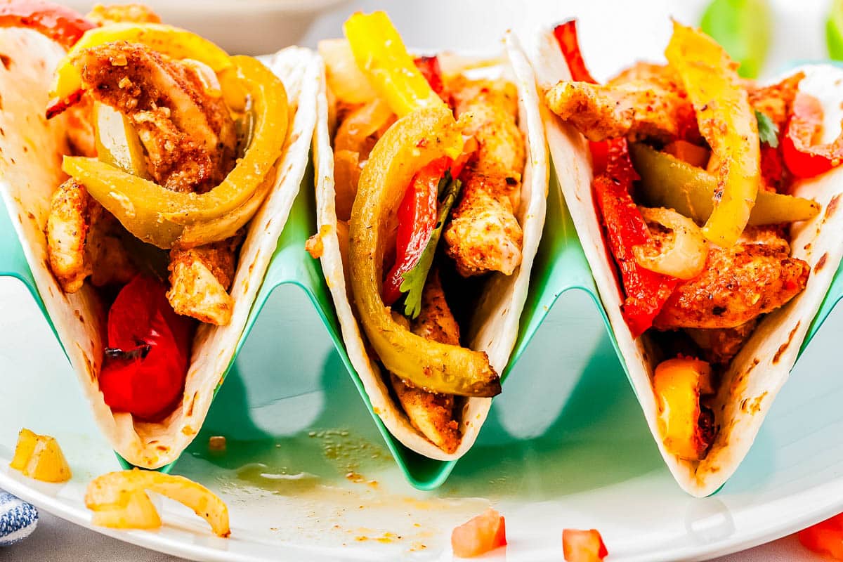 Three Sheet Pan Fajita tacos in a taco holder.