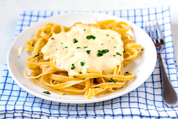 finished fettuccine alfredo on a white plate.