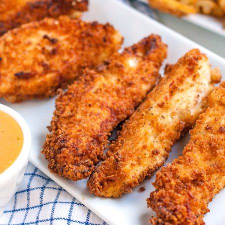 5 Chicken Strips on a white platter.