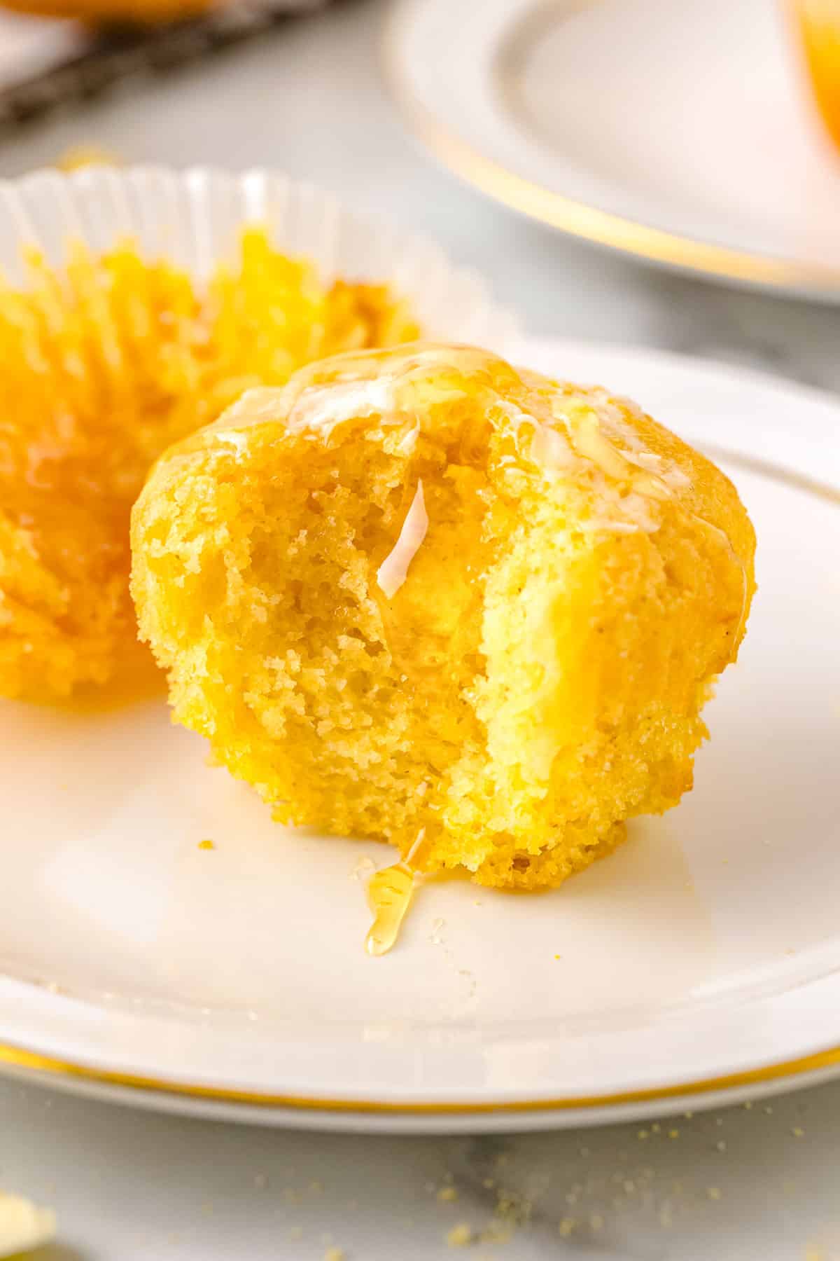 A corn bread muffin bitten into so you can see the moist interior.