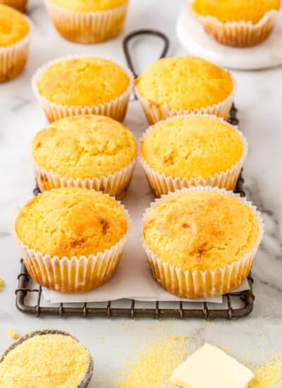 Six corn muffins on a wire rack.