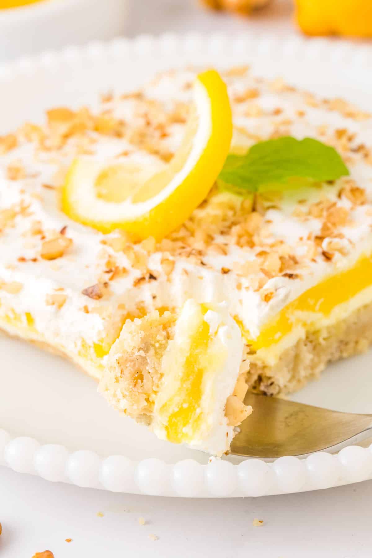 A fork with some of the lemon lush dessert on a fork.
