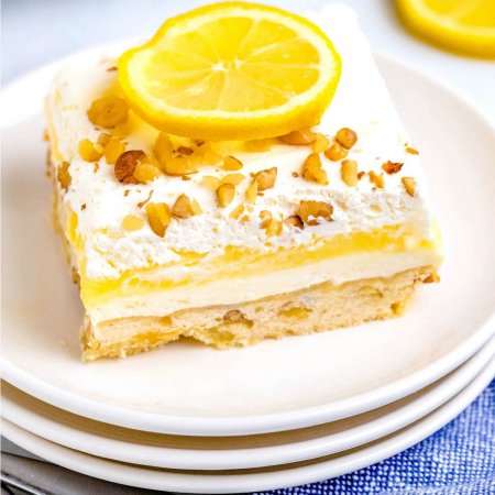 A slice on lemon lush on a white plate showing all of its 4 layers.