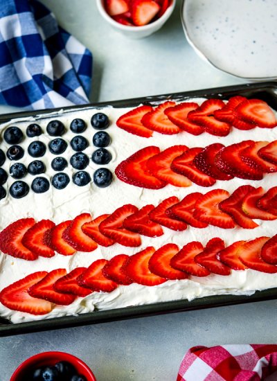 A 4th of July Poke Cake with blueberries and strawberries on it to make it look like an American flag.